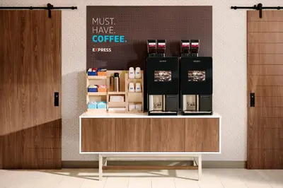 a coffee shop with a counter with a coffee maker on it at Holiday Inn Express Hotel & Suites Carlsbad Beach by IHG in Carlsbad