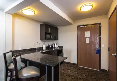 a room with a kitchen with a sink and a counter at Holiday Inn Express Hotel & Suites Carlsbad Beach by IHG in Carlsbad