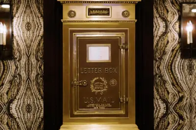 a gold elevator door in a room with a wall at The US Grant, a Luxury Collection Hotel, San Diego in San Diego