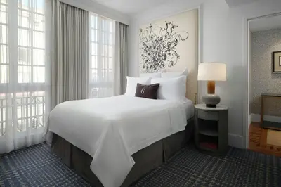 a large white bed in a room with windows at The US Grant, a Luxury Collection Hotel, San Diego in San Diego