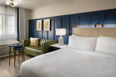 a bedroom with a bed and a couch and a chair at Tiller House, Laguna Hills, a Tribute Portfolio Hotel in Laguna Hills
