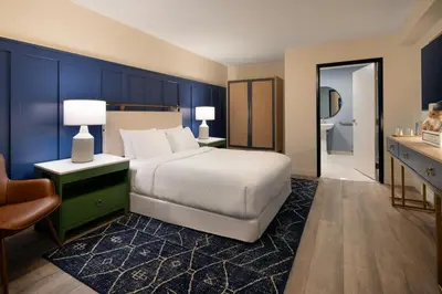 a bedroom with a bed and a desk and a chair at Tiller House, Laguna Hills, a Tribute Portfolio Hotel in Laguna Hills