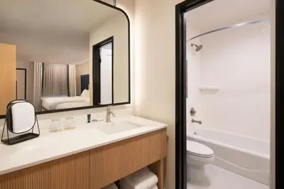 a bathroom with a sink and a toilet and a mirror at Tiller House, Laguna Hills, a Tribute Portfolio Hotel in Laguna Hills