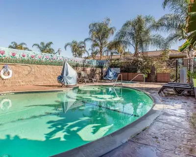 a swimming pool with green water in a yard at Quality Inn Hemet - San Jacinto in Hemet
