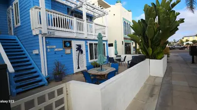 a blue house with a table and chairs on a sidewalk at Luna Azul, cozy condo only steps to Mission Beach! Free Internet in San Diego