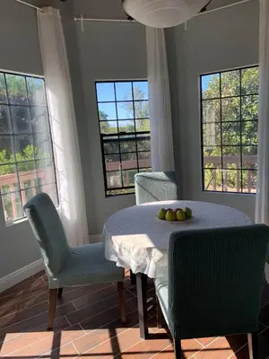 a dining room with a table and chairs and windows at Rancho Garden Home in Rancho Santa Fe