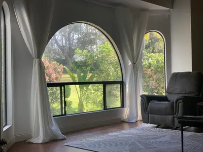 a living room with a chair and a large window at Rancho Garden Home in Rancho Santa Fe