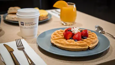 a waffle with strawberries and whipped cream on a table at Best Western Poway/San Diego Hotel in Poway