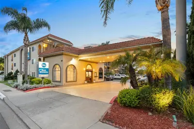 a hotel with palm trees in front of a building at Best Western San Diego/Miramar Hotel in Miramar