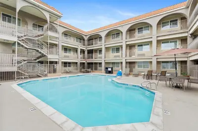 a pool in front of a hotel with tables and chairs at Best Western San Diego/Miramar Hotel in Miramar