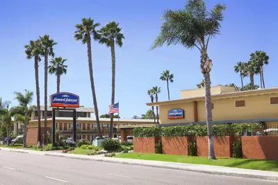 a hotel with palm trees in front of a street at Howard Johnson by Wyndham San Diego Sea World in San Diego