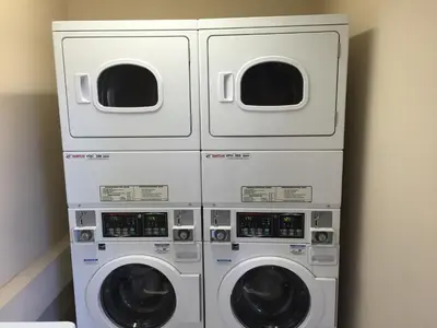 three washing machines in a room next to a wall at Howard Johnson by Wyndham San Diego Sea World in San Diego