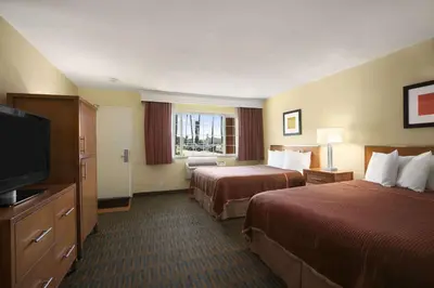 a hotel room with two beds and a flat screen tv at Howard Johnson by Wyndham San Diego Sea World in San Diego