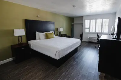 a bedroom with a bed and a desk and a television at Old Town Western Inn in San Diego