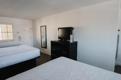 a hotel room with two beds and a flat screen tv at Old Town Western Inn in San Diego