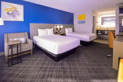 a hotel room with two beds and a chair at Comfort Inn Encinitas Near Legoland in Encinitas