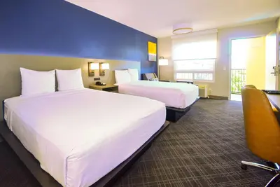 a hotel room with two beds and a chair at Comfort Inn Encinitas Near Legoland in Encinitas