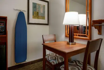 a room with a desk and a surfboard on the wall at Days Inn by Wyndham Encinitas Moonlight Beach in Encinitas