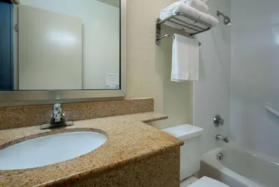 a bathroom with a sink and a toilet and a mirror at Days Inn by Wyndham Encinitas Moonlight Beach in Encinitas