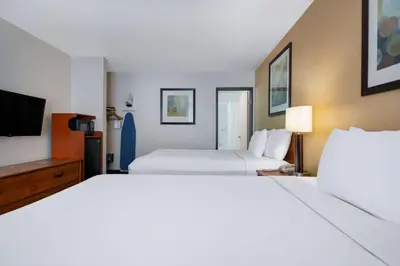 a hotel room with two beds and a flat screen tv at Days Inn by Wyndham Encinitas Moonlight Beach in Encinitas