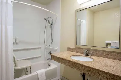 a bathroom with a sink and a shower with a mirror at Days Inn by Wyndham Encinitas Moonlight Beach in Encinitas
