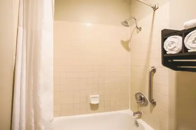 a bathroom with a tub and a shower with towels at La Quinta by Wyndham Carlsbad - Legoland Area in Carlsbad