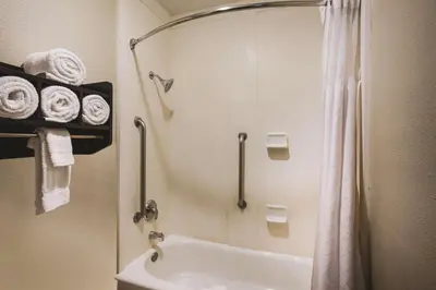 a bathroom with a shower and a white tub at La Quinta by Wyndham Carlsbad - Legoland Area in Carlsbad