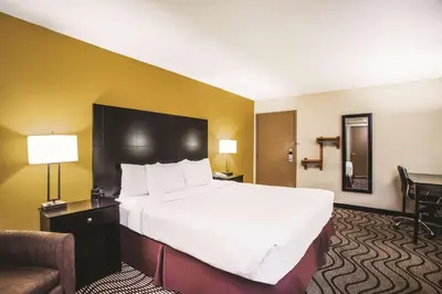 a hotel room with a large bed and a chair at La Quinta by Wyndham Carlsbad - Legoland Area in Carlsbad