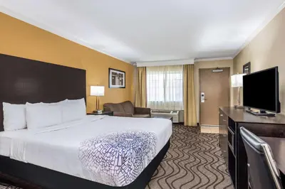 a hotel room with a bed and a flat screen tv at La Quinta by Wyndham Carlsbad - Legoland Area in Carlsbad