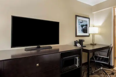 a hotel room with a television and a desk with a chair at La Quinta by Wyndham Carlsbad - Legoland Area in Carlsbad