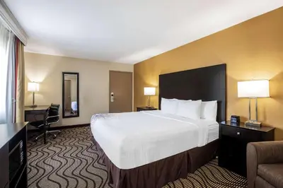 a hotel room with a large bed and a chair at La Quinta by Wyndham Carlsbad - Legoland Area in Carlsbad