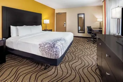 a hotel room with a large bed and a desk at La Quinta by Wyndham Carlsbad - Legoland Area in Carlsbad