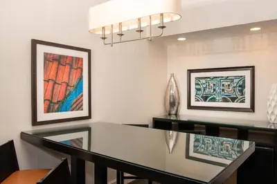 a dining room with a glass table and artwork at Sheraton Mission Valley San Diego Hotel in San Diego