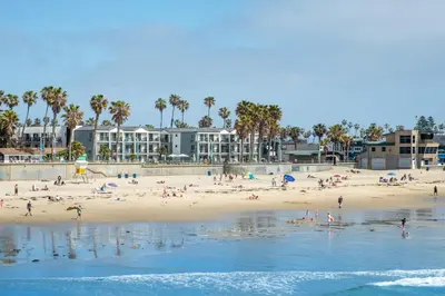 a group of people on a beach near the water at Ocean Park Inn in San Diego