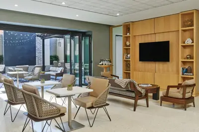 a lobby with chairs and tables and a television at Hotel Republic San Diego, Autograph Collection in San Diego