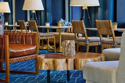 a living room with chairs and a table with a tree stump coffee table at Hotel Republic San Diego, Autograph Collection in San Diego