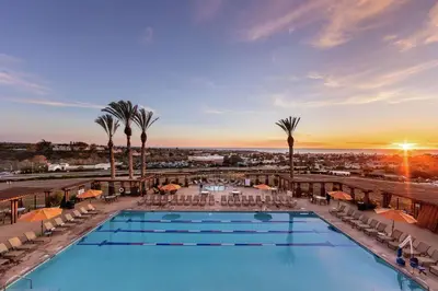 a view of the pool at a resort with palm trees at The Cassara Carlsbad, Tapestry Collection By Hilton in Carlsbad