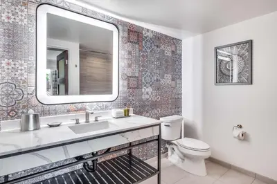 a bathroom with a sink and a toilet and a mirror at The Cassara Carlsbad, Tapestry Collection By Hilton in Carlsbad