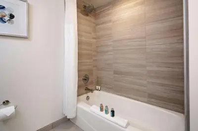 a bathroom with a white bath tub and wooden walls at The Cassara Carlsbad, Tapestry Collection By Hilton in Carlsbad