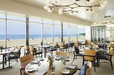 a restaurant with tables and chairs and the beach at Waldorf Astoria Monarch Beach Resort & Club in Dana Point