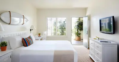 a white bedroom with a bed and a mirror at Laguna Beach House in Laguna Beach
