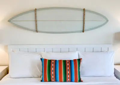 a mirror above a bed with white pillows at Laguna Beach House in Laguna Beach