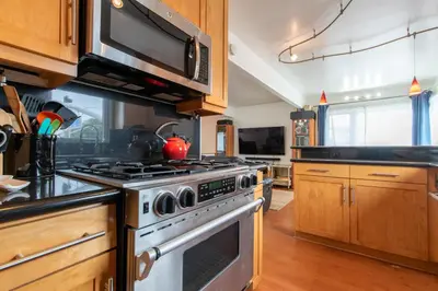 a kitchen with a stove and a microwave at Newport Beach House 1 block from the beach FREE pickleball courts and 6 beach cruisers in Newport Beach