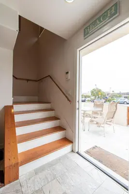 a staircase in a building with a sliding glass door at Newport Beach House 1 block from the beach FREE pickleball courts and 6 beach cruisers in Newport Beach