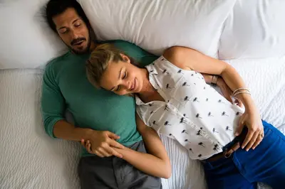 a man and a woman laying on a bed at The Sofia Hotel in San Diego