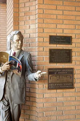 a statue of a man standing next to a brick wall at The Sofia Hotel in San Diego