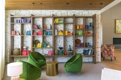 a room with two green chairs and a book shelf at Town and Country San Diego in San Diego