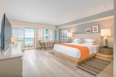 a bedroom with a bed and a desk and a table at Beach Terrace in Carlsbad