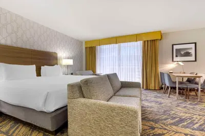 a hotel room with a bed and a couch and a table at Best Western Plus Bayside Inn in San Diego