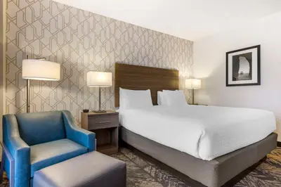 a bedroom with a bed and a blue chair at Best Western Plus Bayside Inn in San Diego